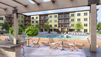 a pool with chairs and tables in front of an apartment building at Boardwalk at Research Park, Huntsville, AL, 35811